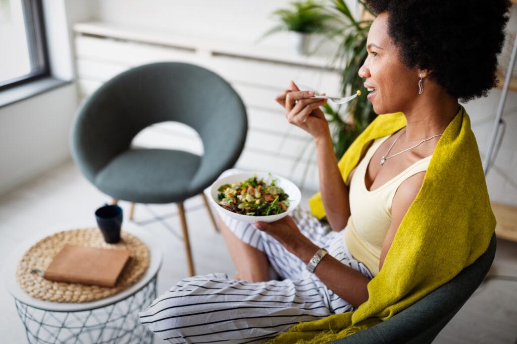 Beautiful black woman eating healthy fresh organic salad.