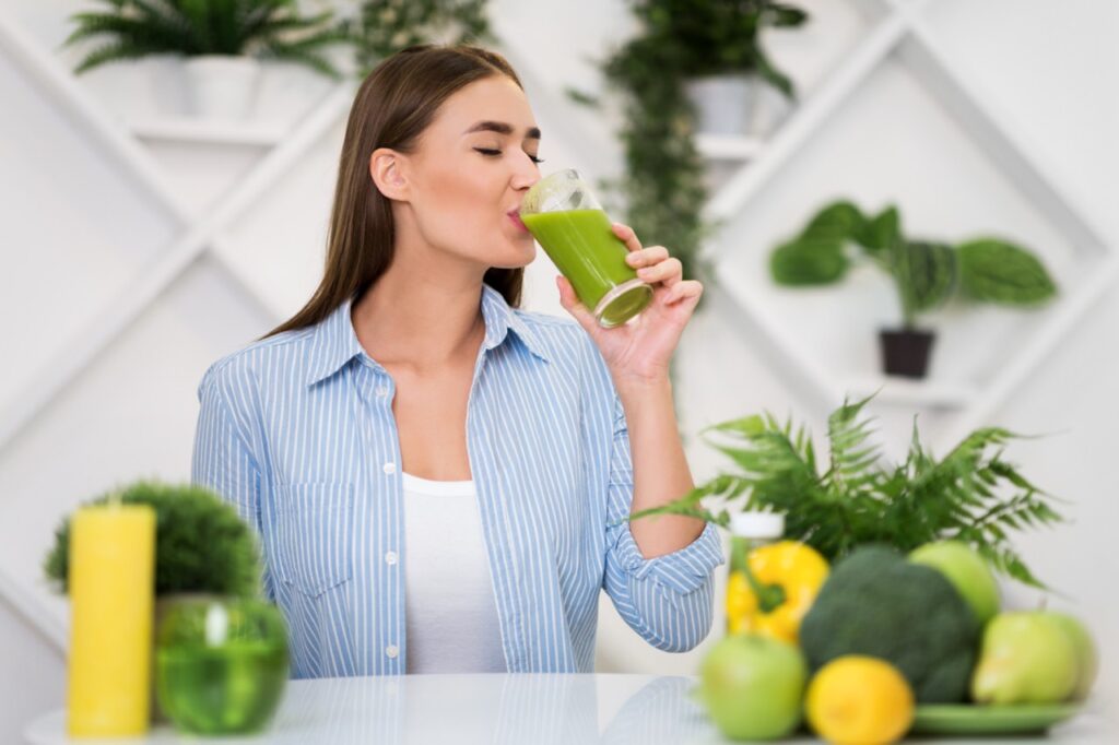 Woman drinking freshly squeezed detox drink.