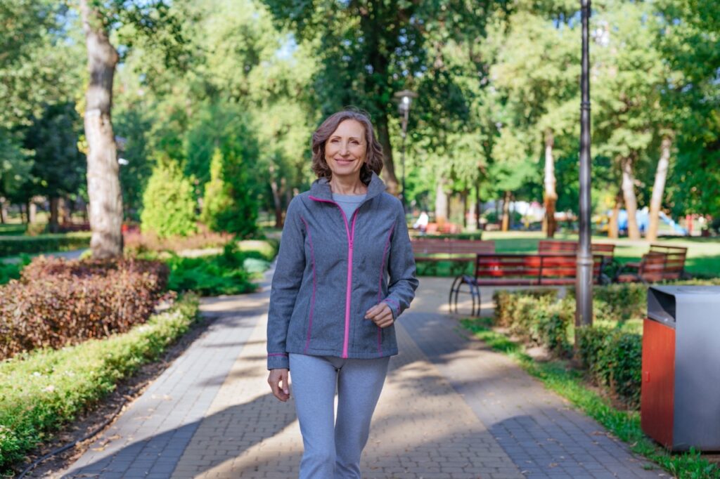Happy mature woman walking in the park.