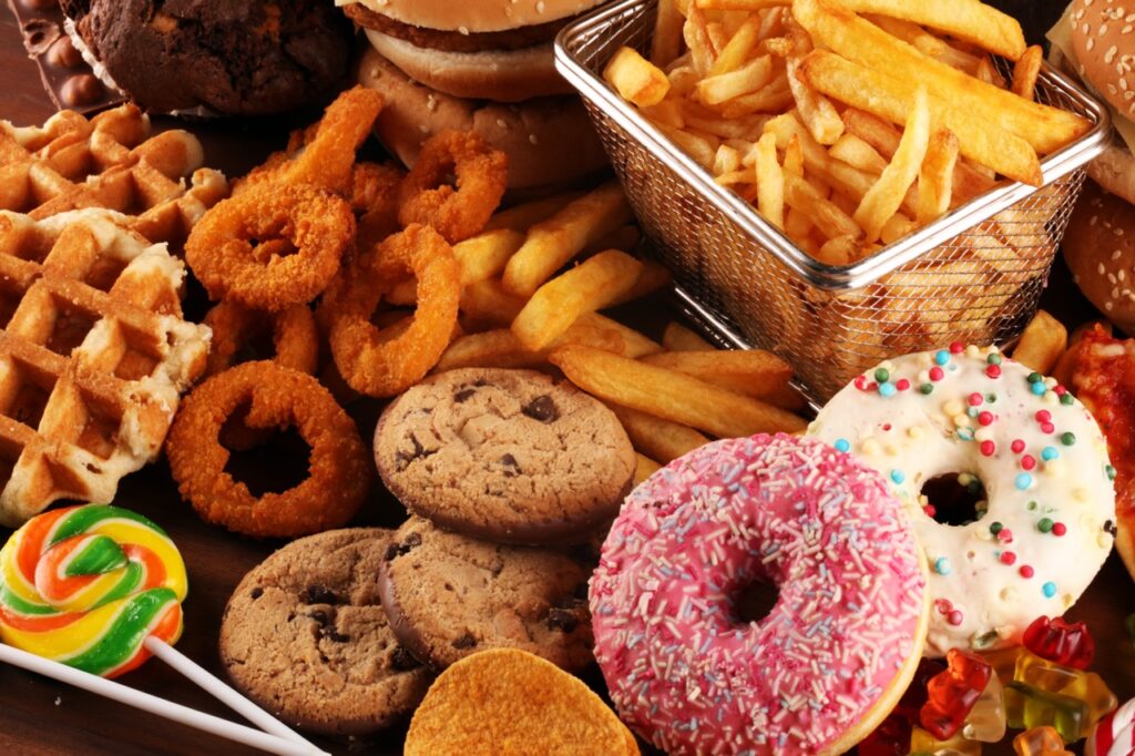 Unhealthy food bad for figure, skin, heart and teeth. Assortment of fast carbohydrates food with fries and cola.