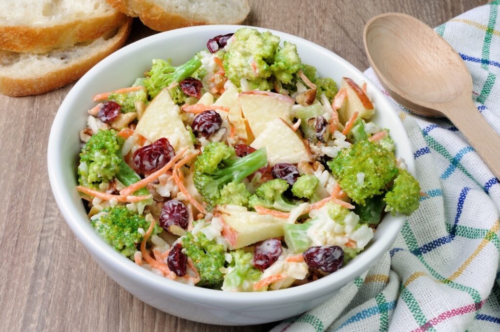 Salad of broccoli, carrots, apples, rice, cranberries and walnuts dressed with yogurt.