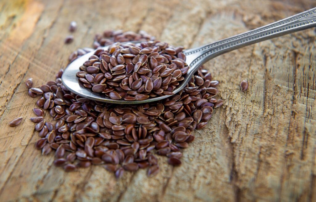 flaxseeds in spoon on wood table