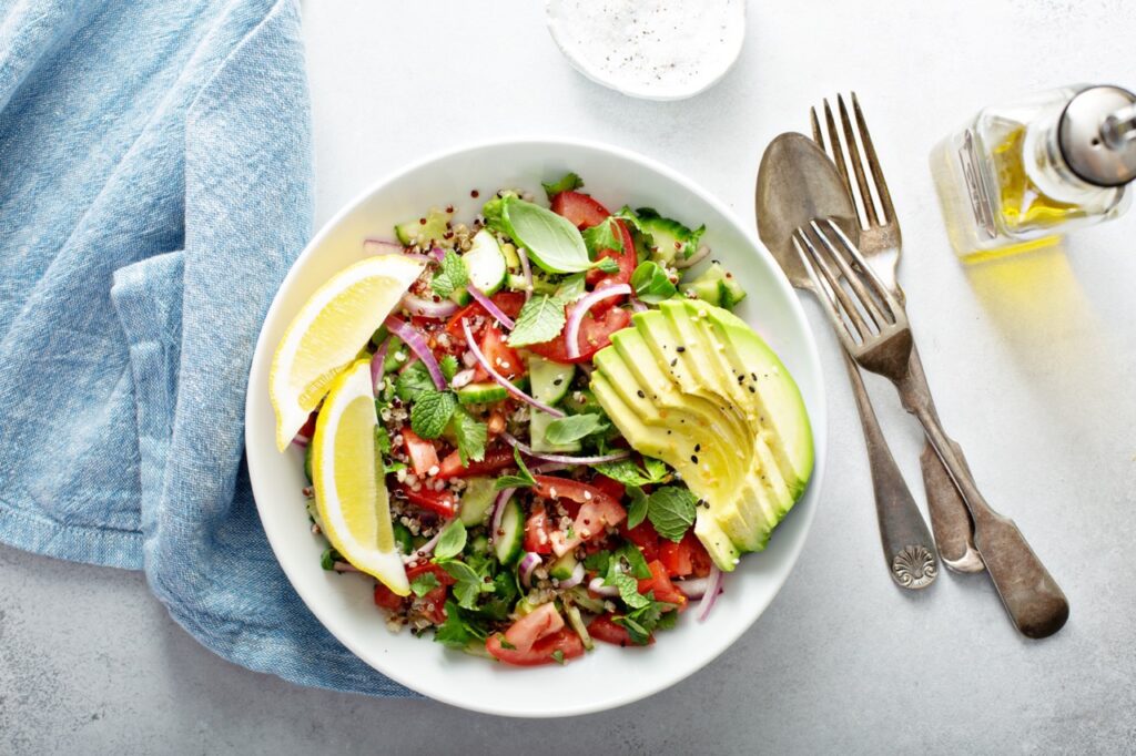 Fresh vegetables and quinoa salad with avocado and lemon dressing.