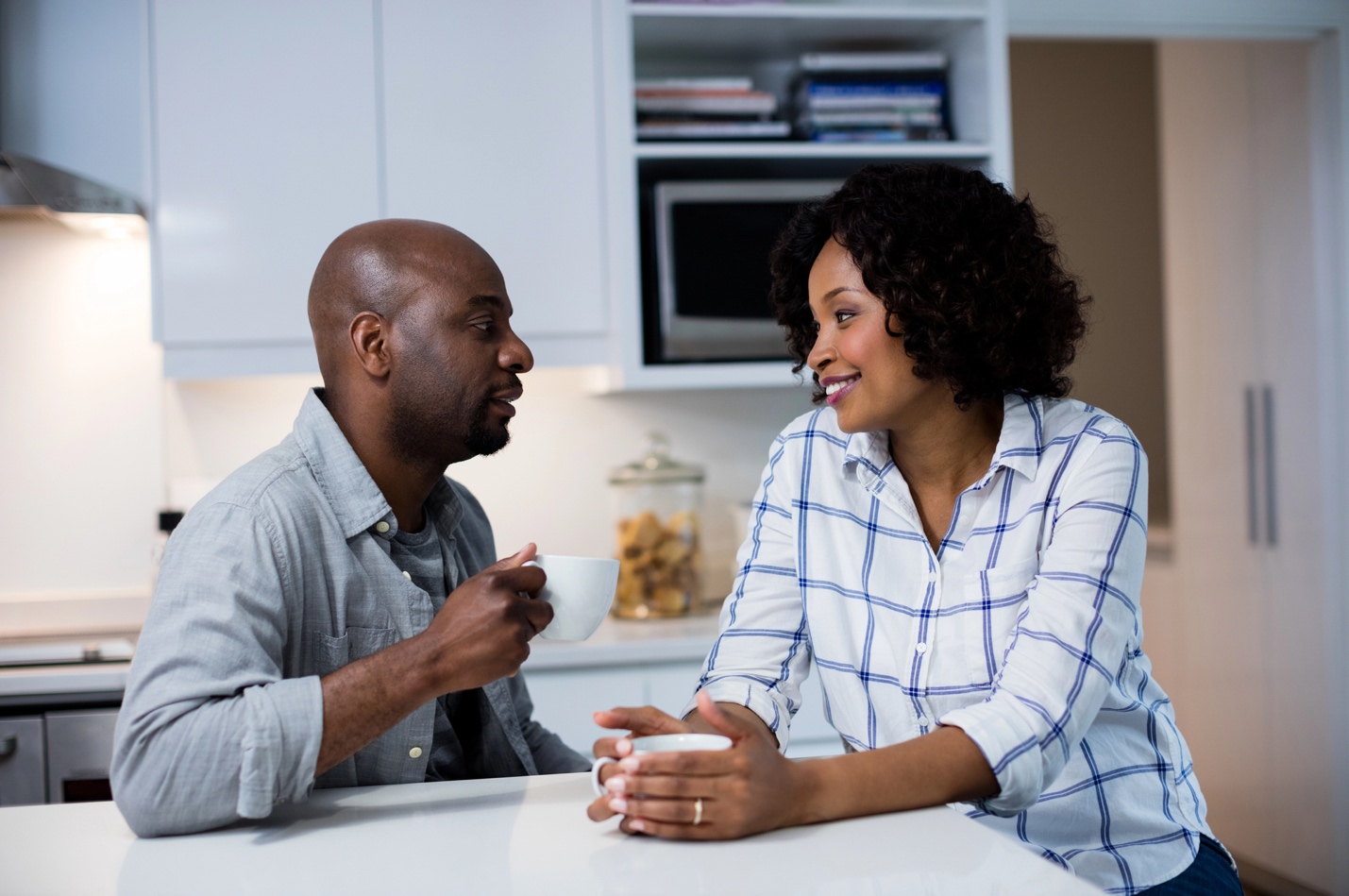 A man and woman sitting at a table talking.
