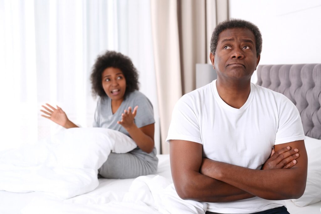 Black couple arguing in bed.