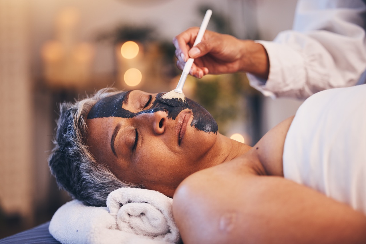 Mature woman receiving a professional facial treatment, supporting skin renewal and collagen stimulation during menopause